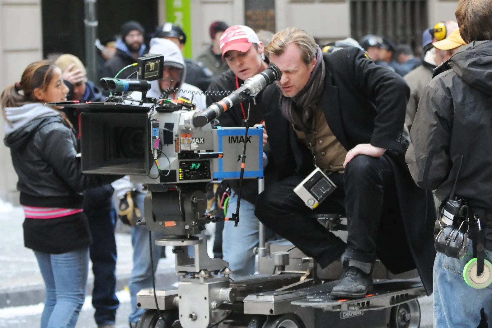 Christopher Nolan on set beside a film camera