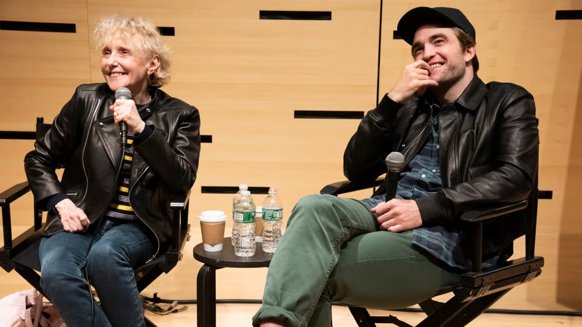 Claire Denis and Robert Pattinson sit together onstage holding microphones.