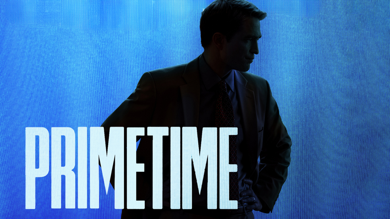 Robert Pattinson stands in silhouette against a blue television-style background reading Primetime.