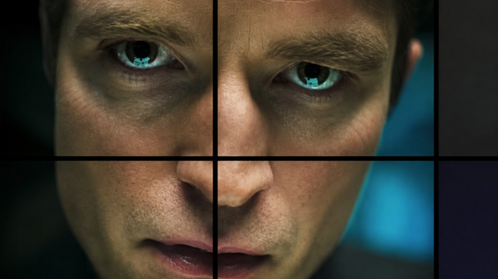 A close view of Robert Pattinson's face is divided by dark lines resembling multiple television monitors.