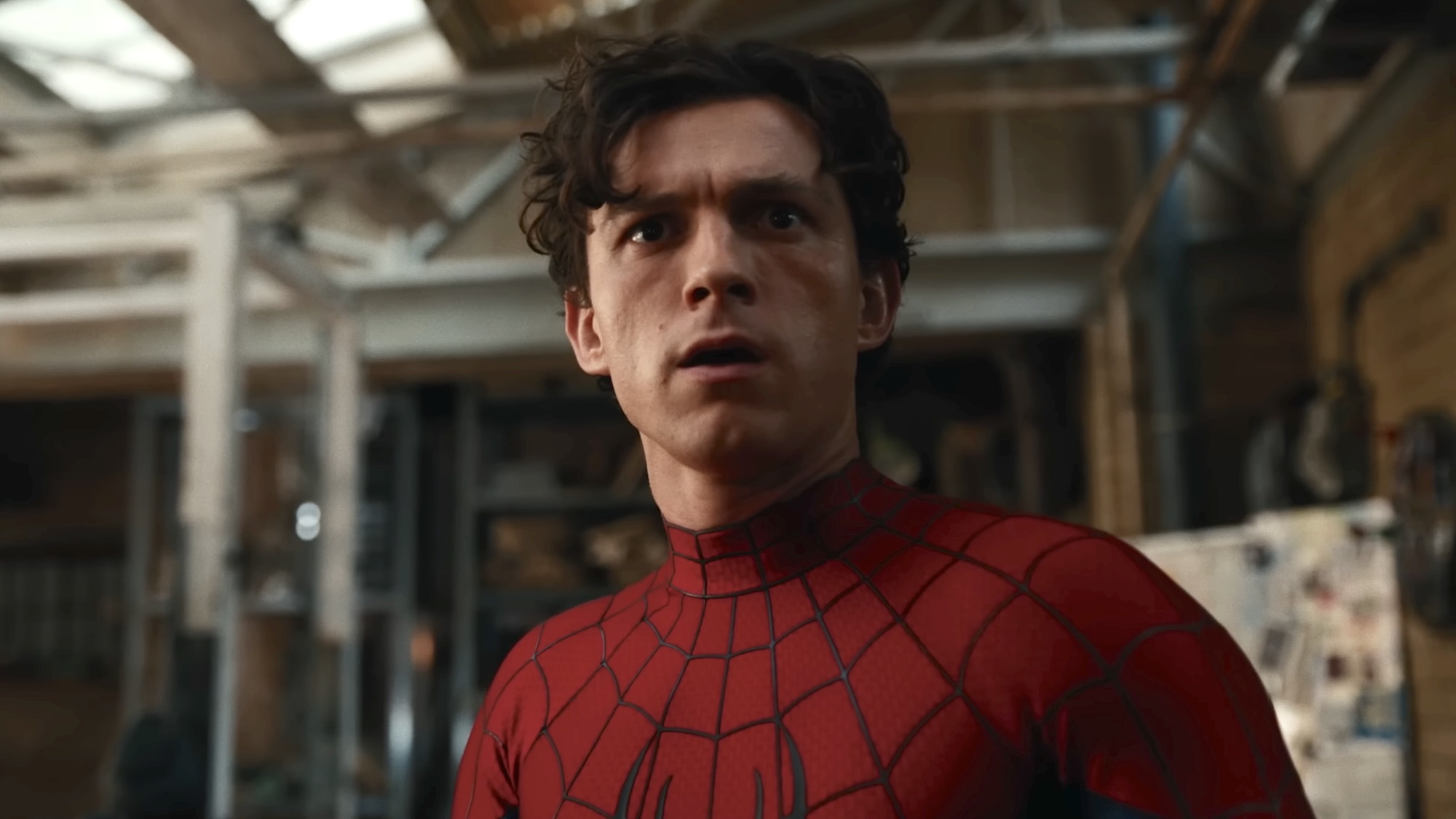 Peter Parker looks ahead while wearing the Spider-Man suit with the mask removed.
