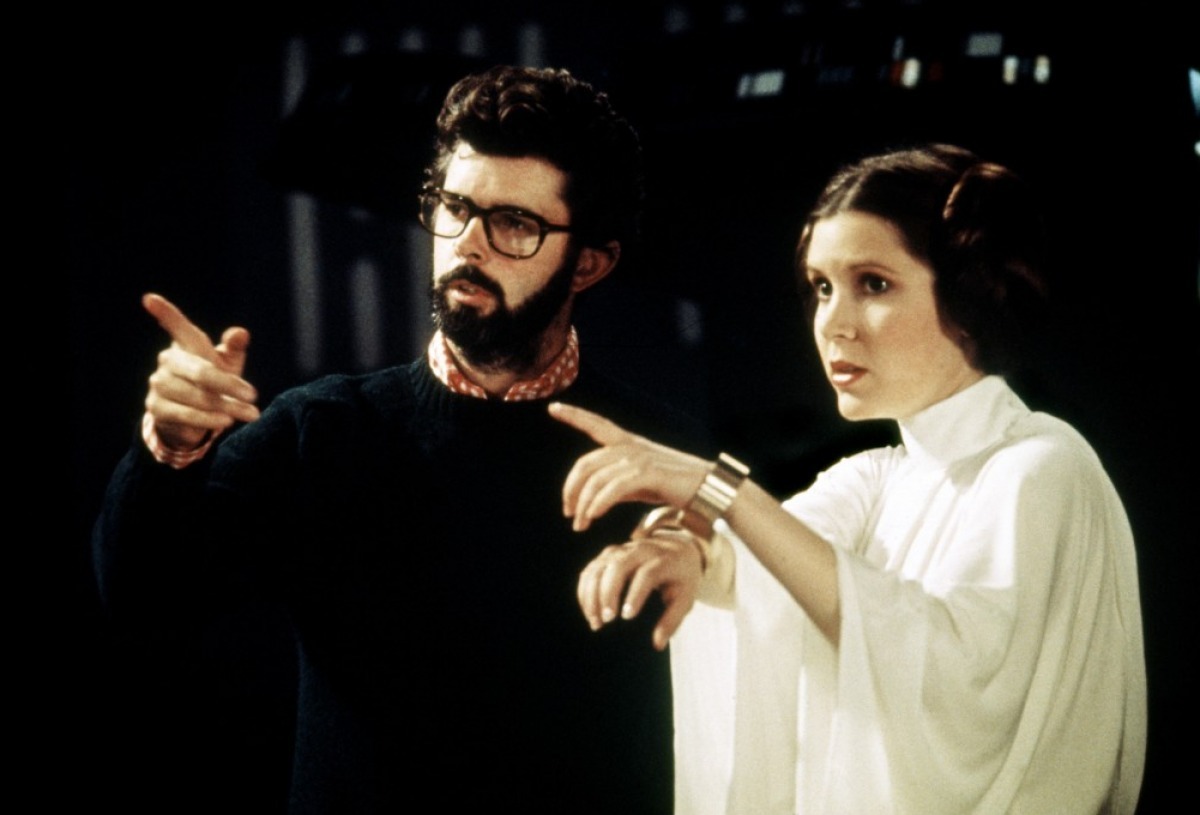 George Lucas gestures beside Carrie Fisher while working on Star Wars.