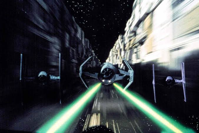 TIE fighters pursue a Rebel starfighter through the Death Star trench during the final battle in Star Wars.