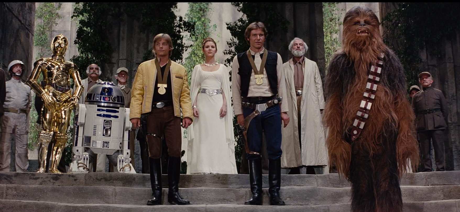 C-3PO, R2-D2, Luke Skywalker, Princess Leia, Han Solo and Chewbacca stand together during the Rebel medal ceremony.