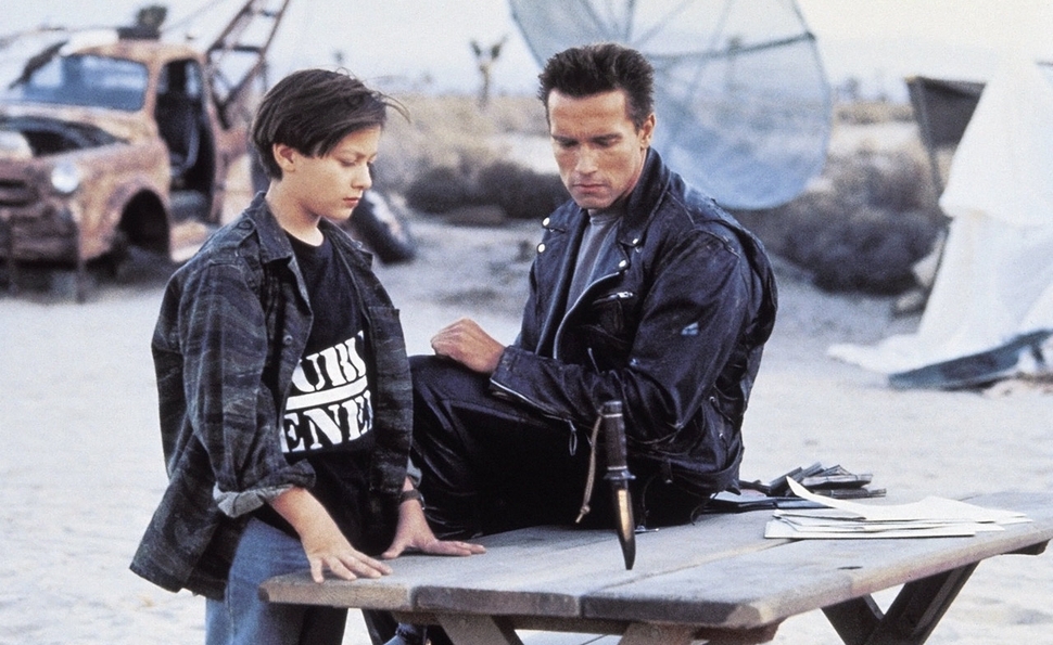 Edward Furlong as John Connor sits beside Arnold Schwarzenegger’s T-800 in Terminator 2: Judgment Day.