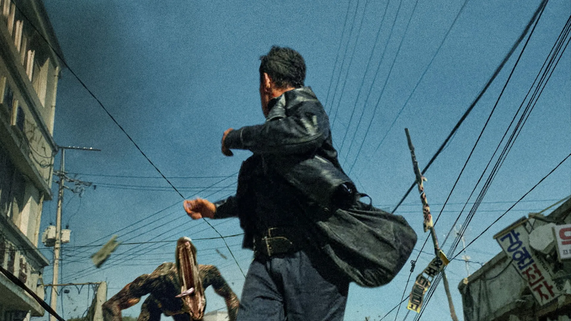 A man turns toward a charging creature on a street in Na Hong-jin’s Hope.