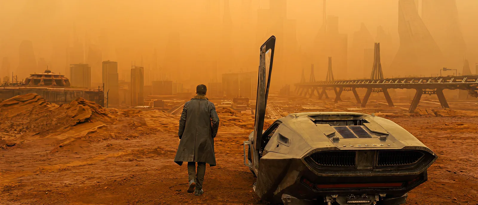 K walks away from his spinner through the vast orange ruins of Las Vegas in Blade Runner 2049.
