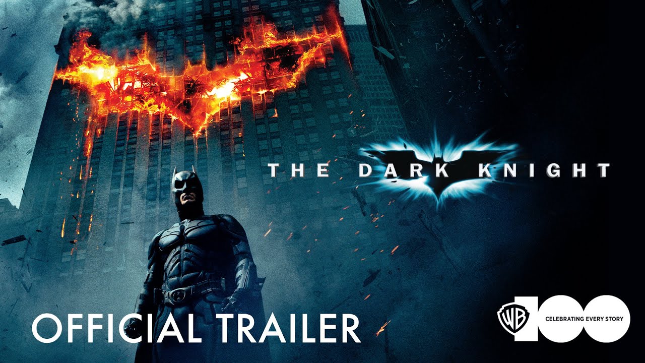 Promotional artwork for the official trailer of The Dark Knight shows Batman beneath a burning bat symbol.