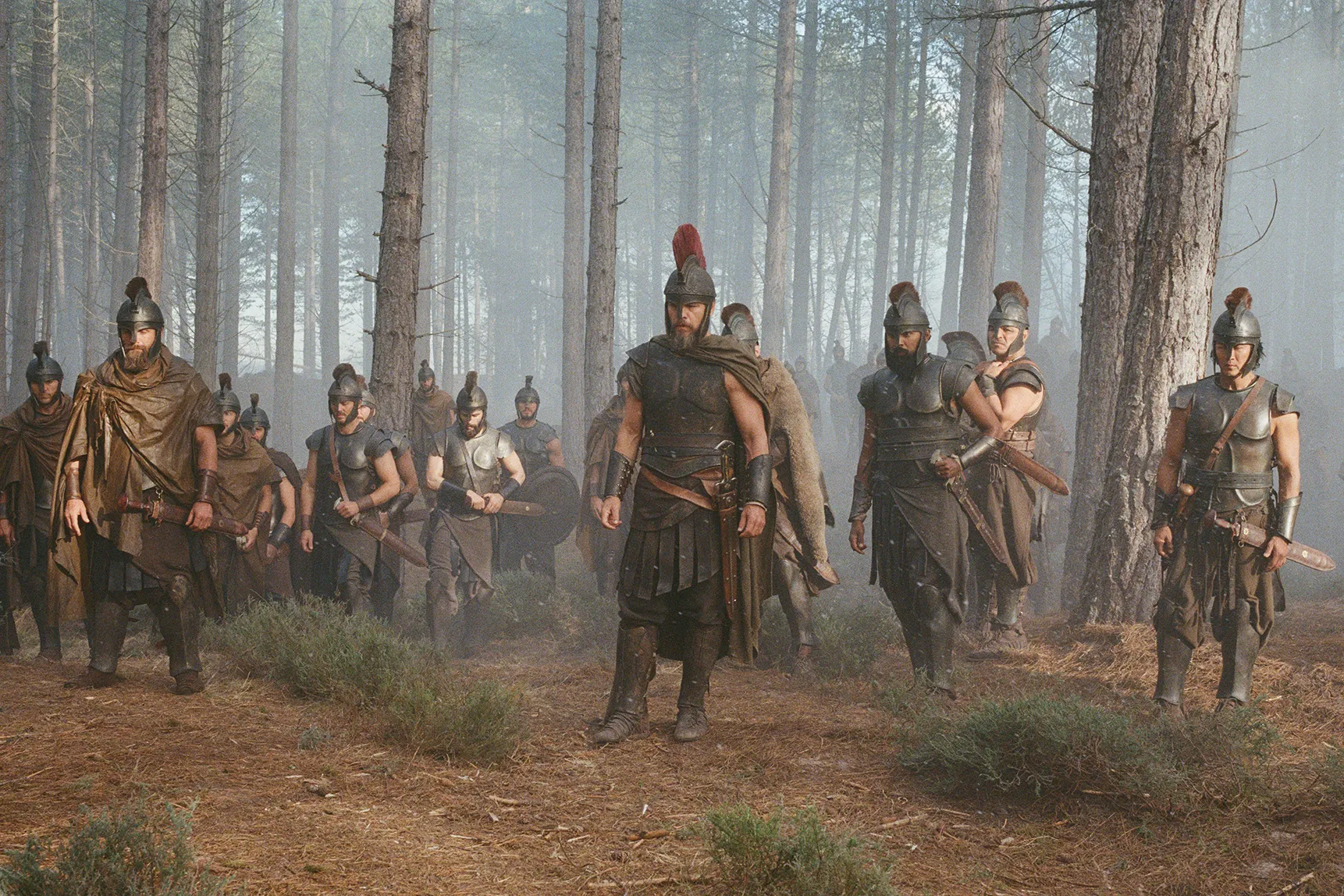Armored Greek soldiers stand among the trees in Christopher Nolan’s The Odyssey.
