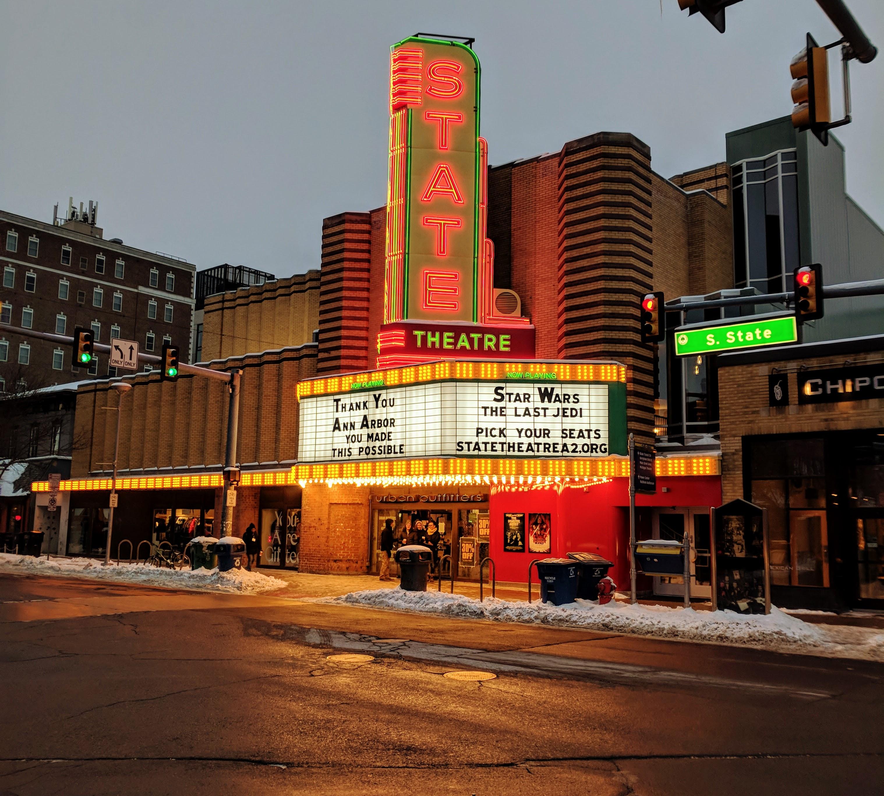 The illuminated State Theatre marquee stands at a downtown Ann Arbor intersection.