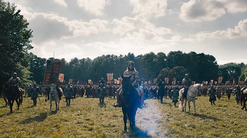 Mounted soldiers and a large medieval army gather beneath banners in an open field in The Uprising.
