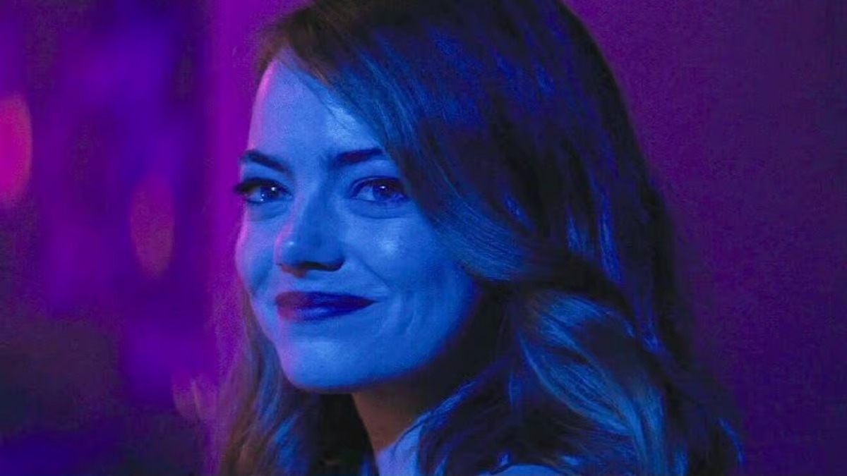Mia smiles under blue and purple light near the end of La La Land.