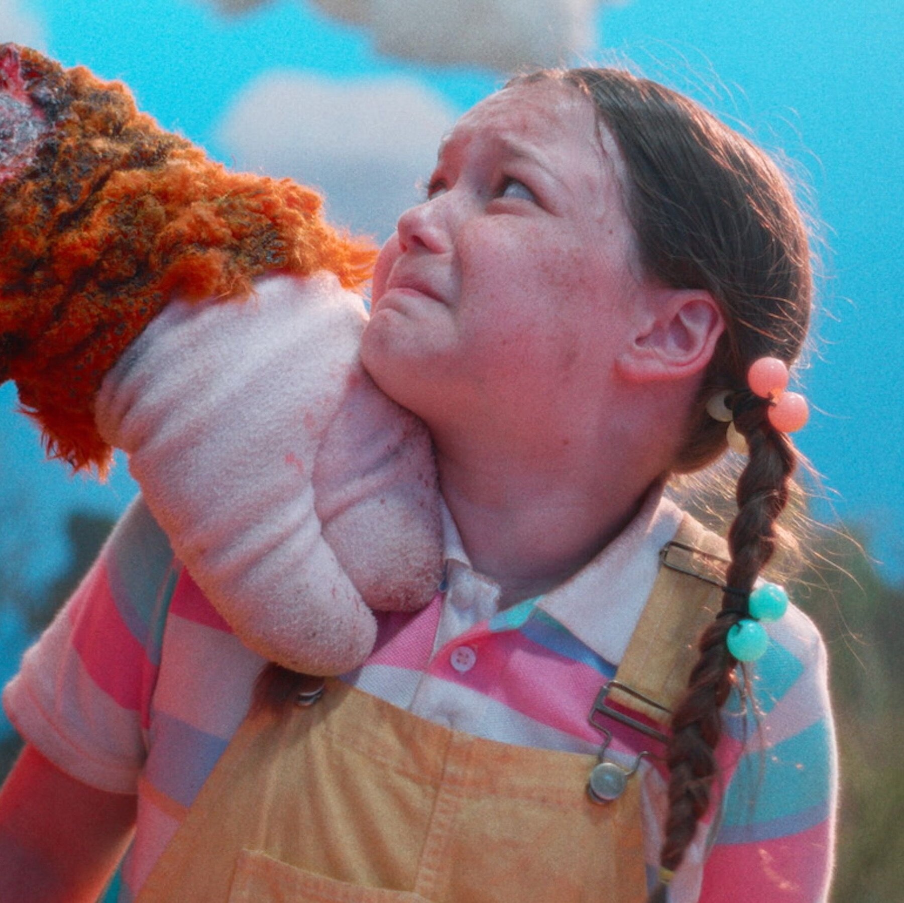 A frightened young girl clutches a plush toy in Buddy.