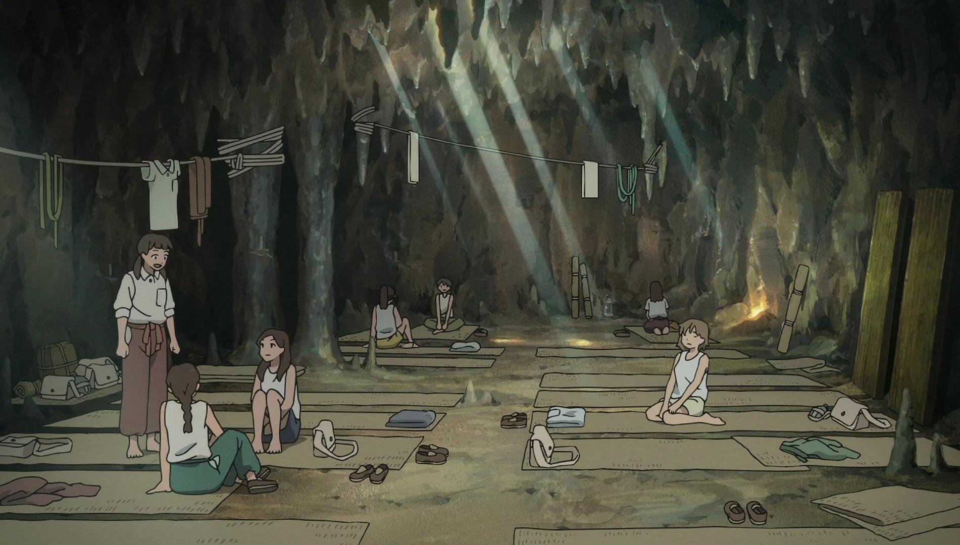 Schoolgirls rest and work on mats inside a cave converted into a wartime hospital.
