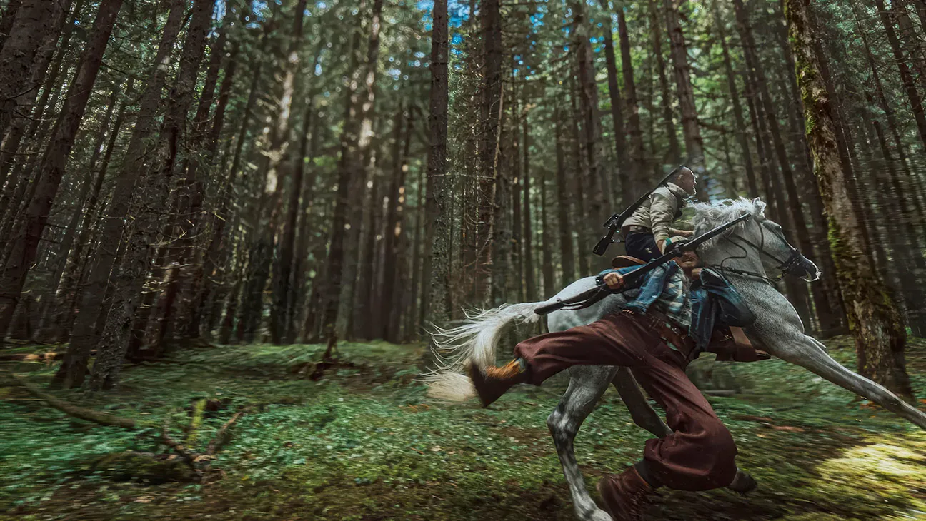 A rider charges through a forest on horseback during an action sequence in Hope.