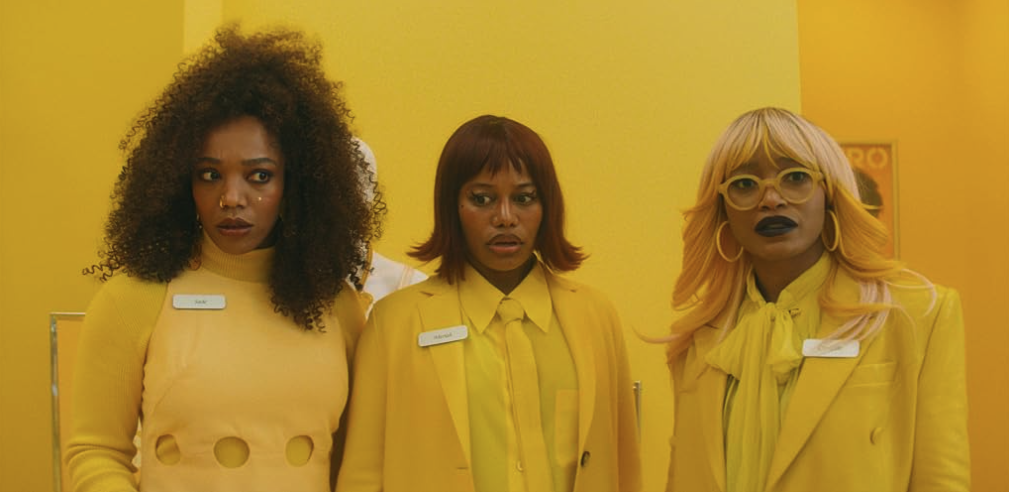 The crew walks together through a retail space in matching bright outfits.
