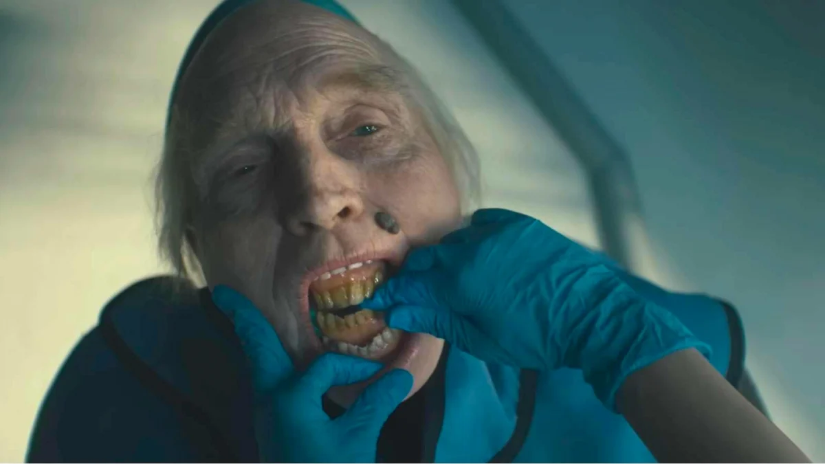 A gloved dental worker examines an elderly patient’s teeth in Insidious: Out of the Further.