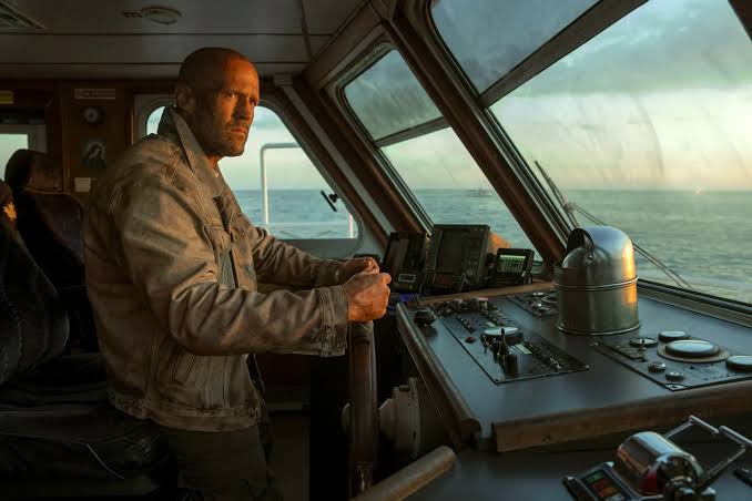 Jason Statham stands at the controls on the bridge of a cargo ship in Mutiny.