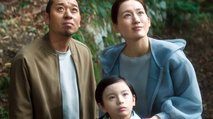 A father, mother, and son looking up together outdoors