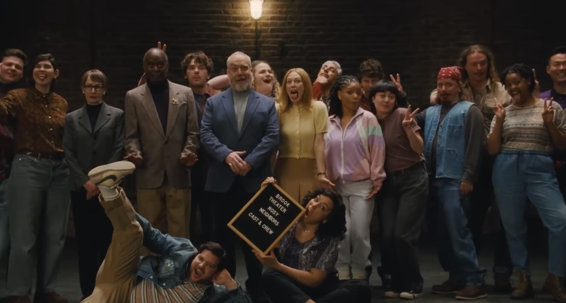 The cast and crew of a community-theater production pose together on a stage.