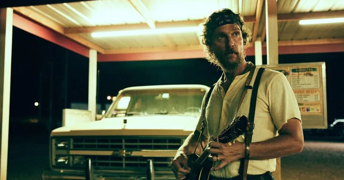 Matthew McConaughey stands outside at night holding a firearm in The Rivals of Amziah King.