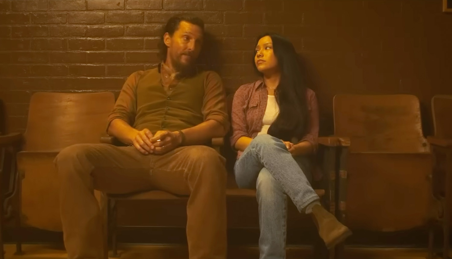 Matthew McConaughey and Angelina LookingGlass sit beside each other in an empty theater in The Rivals of Amziah King.