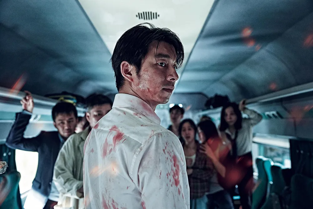 Gong Yoo stands bloodied inside a crowded train car in Train to Busan.