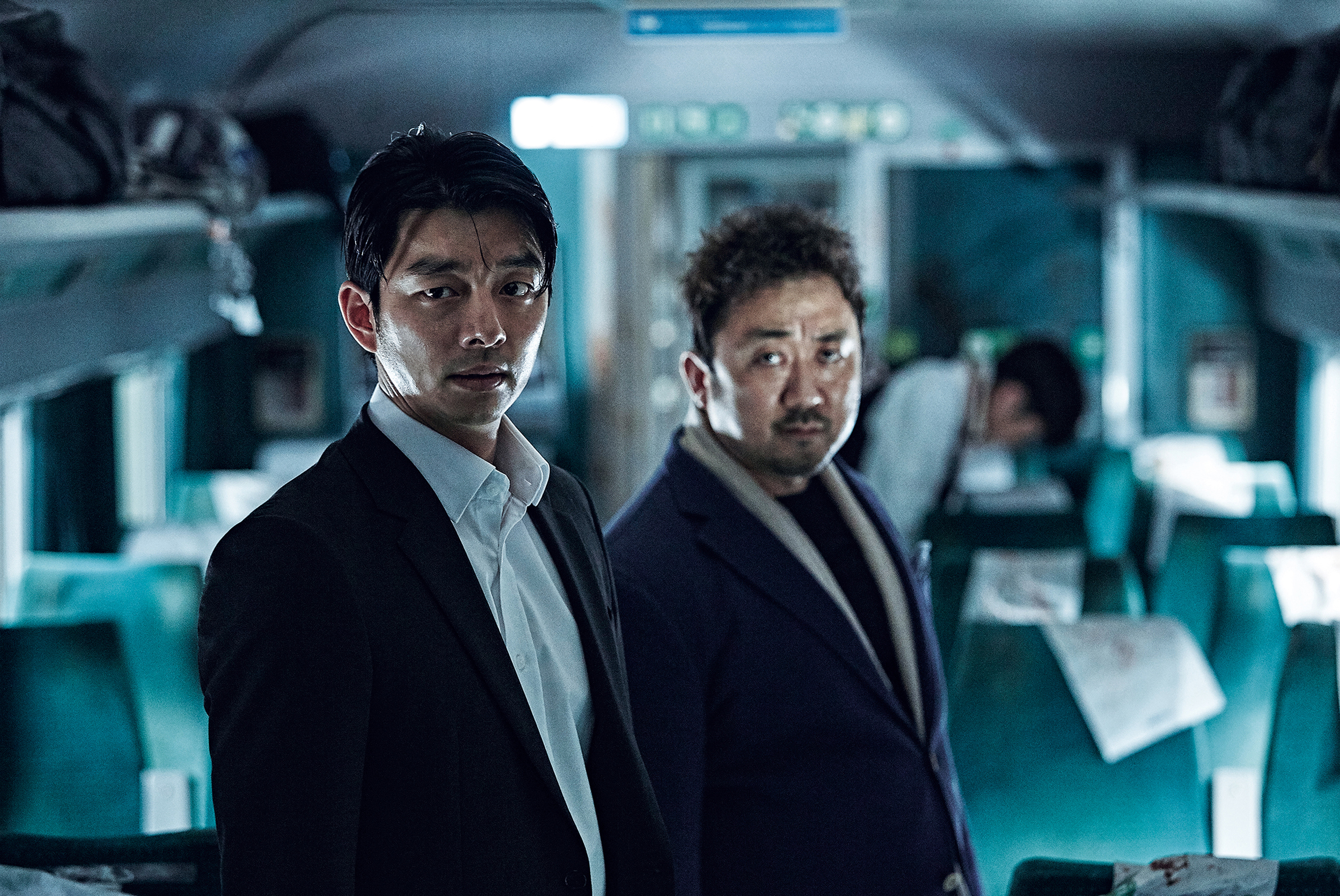 Gong Yoo and Ma Dong-seok stand inside a damaged train car in Train to Busan.