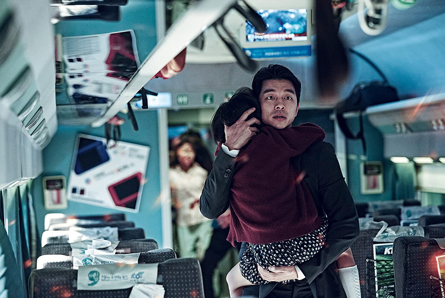 Gong Yoo carries his daughter through a damaged passenger car in Train to Busan.